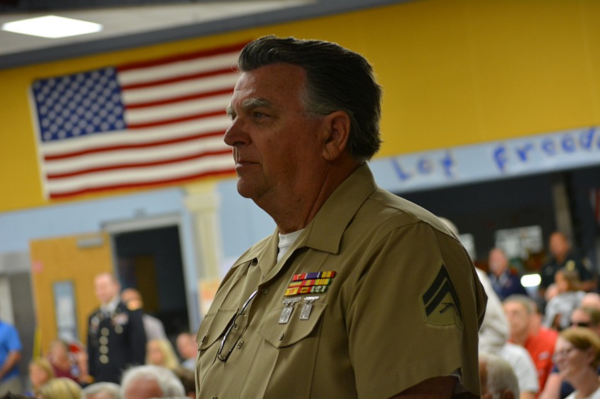 U.S. Marine Cpl. Rick Johnson stands during a patriotic medley recognizing the U.S. Marines. He served in the Vietnam War.