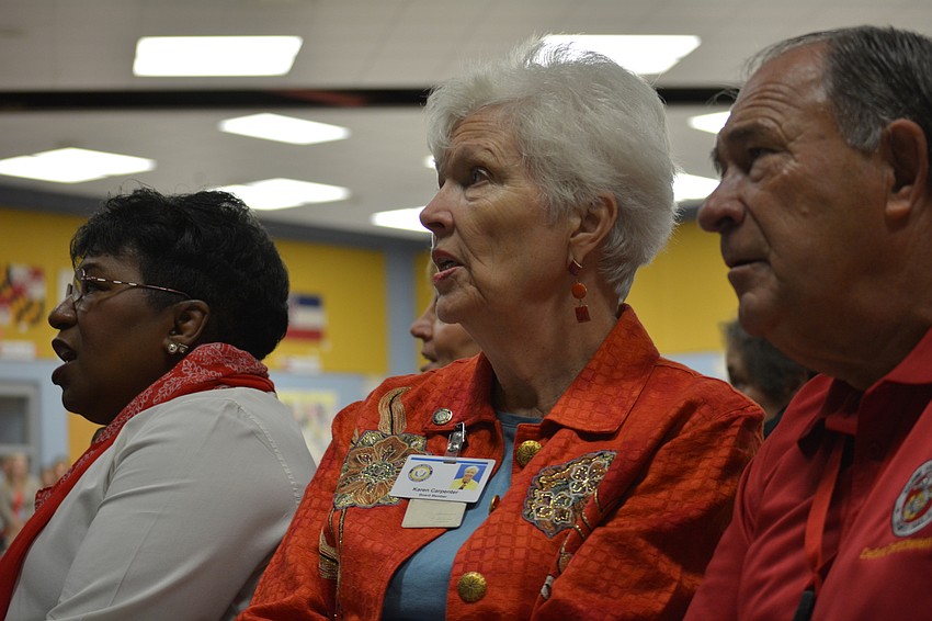 Manatee County School Board member Karen Carpenter, center, sings along to a patriotic song, as does Superintendent Dr. Diana Greene, left, and School Board member Dave Miner, right.