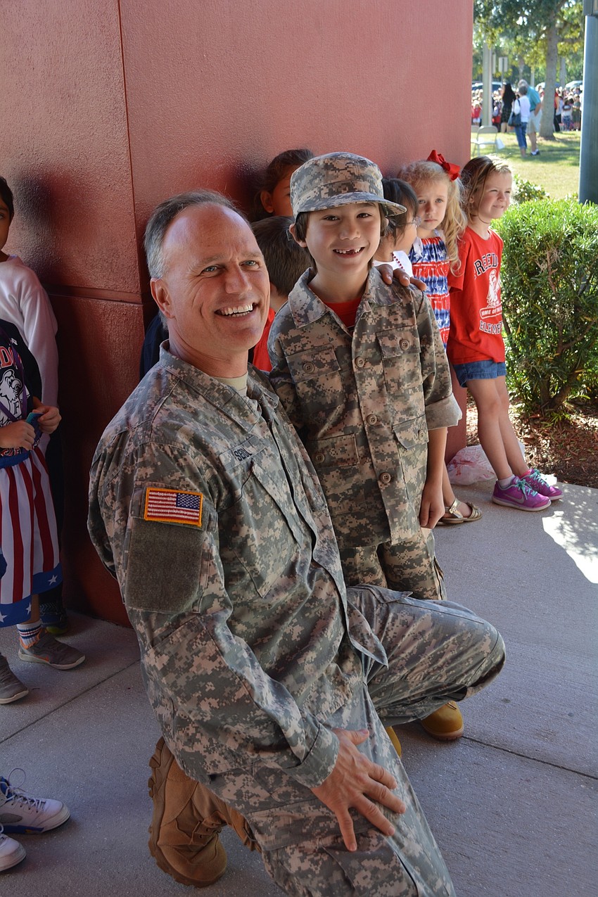 U.S. Army Department of Veterans Affairs organization development psychologist Troy Seidl greets his son, Liam, 6, who came dressed in matching camouflage.