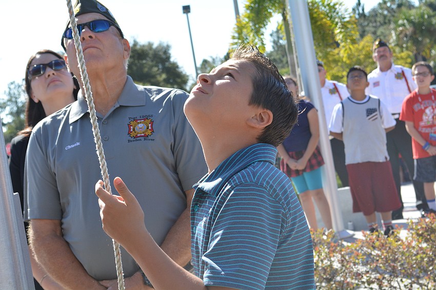 Alex Angelo pulls up a military flag with the help of Vietnam veteran Chuck Slenker, of VFW Post 12055.