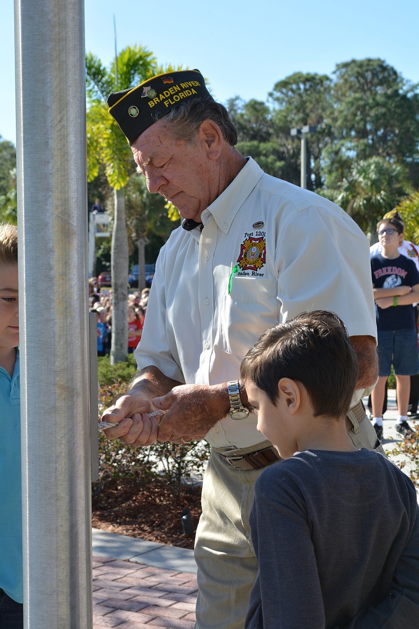 U.S. Army veteran Dieter Zoellner shows Sebastian Ramos, 8, how to tie a knot.