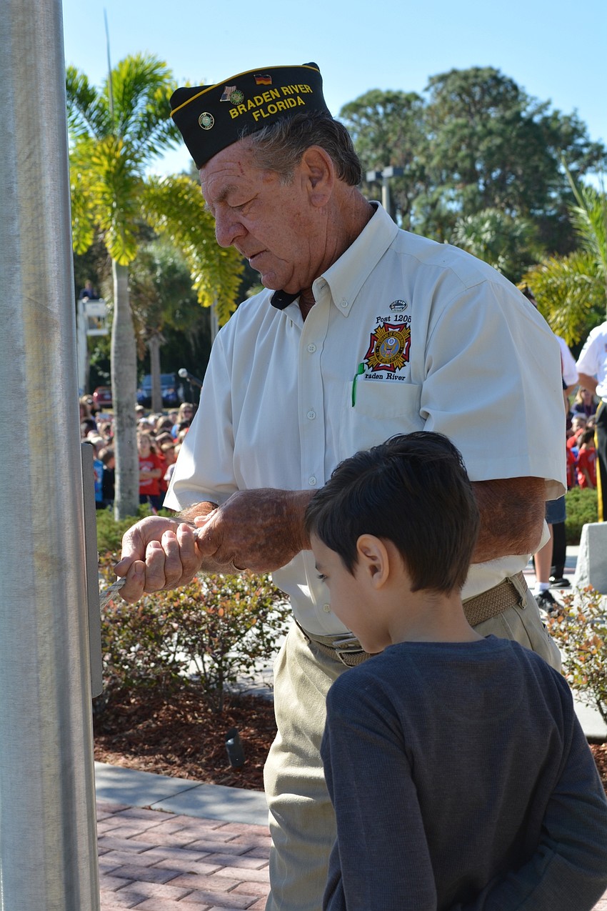 U.S. Army veteran Dieter Zoellner shows Sebastian Ramos, 8, how to tie a knot.