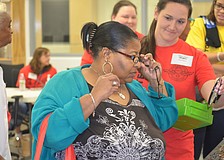 Bradenton's Zanthia Monroe tries on glasses with help from Sarasota volunteer Jenny King.