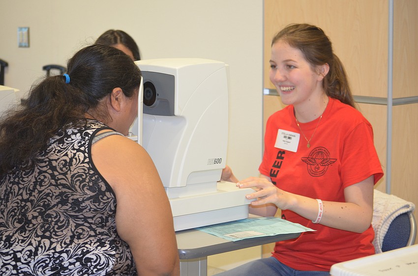 Bradenton's Viviana Reyes gets her eyes checked by Stella Varain, a volunteer from Tampa.