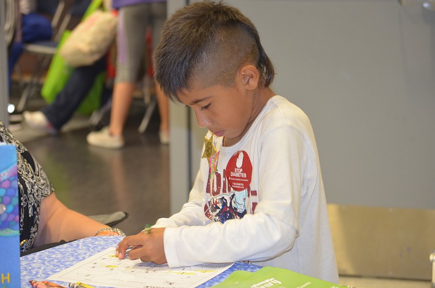 Oswald Rodrigues, 7, colors while his mom gets dental care at RAM.