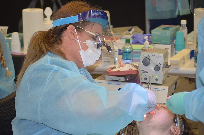 Bradenton's Shannon Murphy, a dental hygiene student, cleans the teeth of Sarasota's Robin Salisbury.