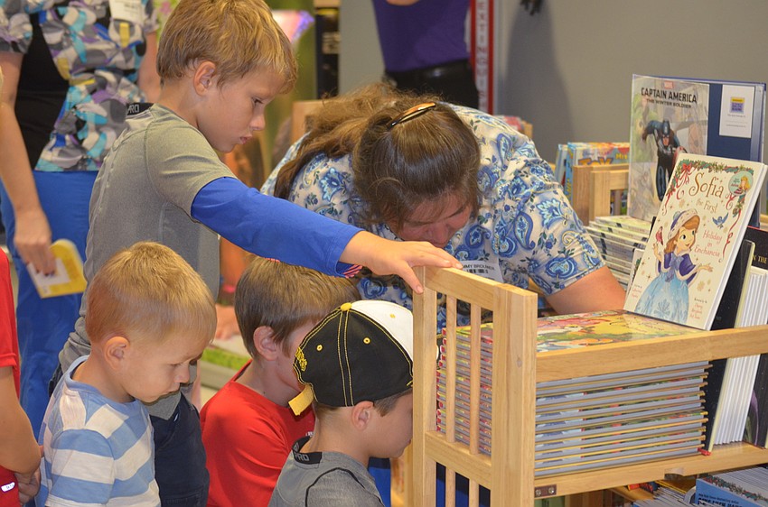 East Bradenton's Tammy Brouwer, a volunteer at the Remote Area Medical free clinic, helps a group of young children pick out some free books.