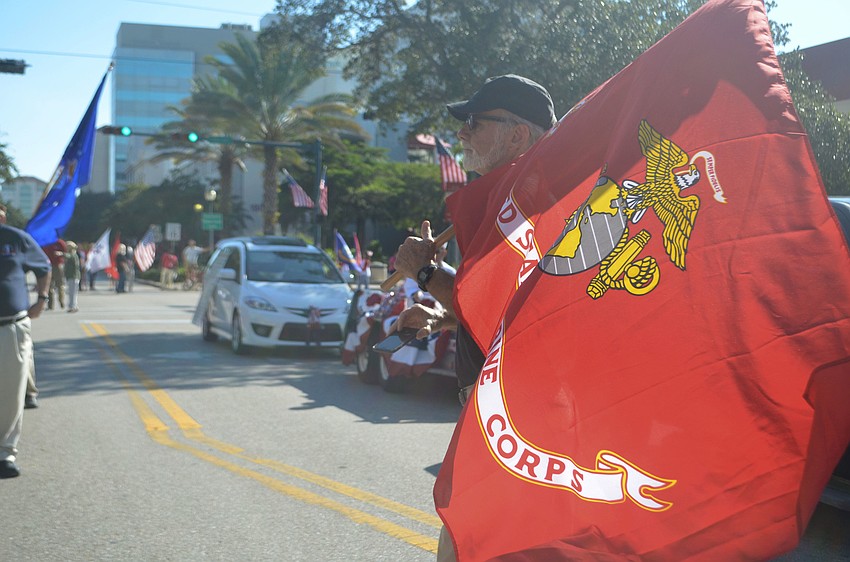 President of the Florida Veterans for Common Sense Gene Jones holds the Marine Corps flag on Main Street before the parade began. The group is active in community events such as organizing the  female veterans conference.