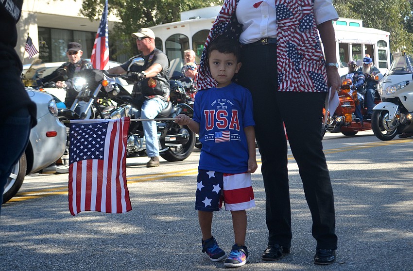 Dede Travieso holds and American flag while waiting to march  with Junior Auxiliary League in the Veterans Day Parade.