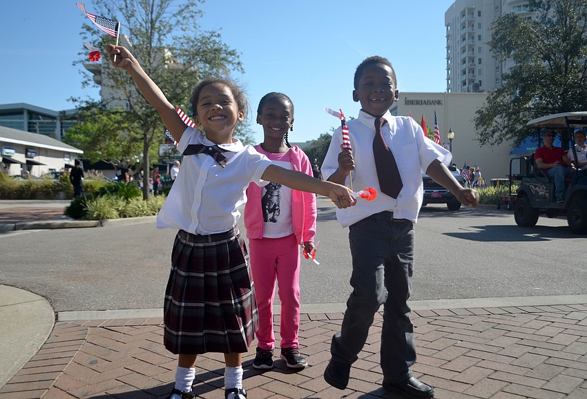 Jaliyah Campbell, Hadra Porter and Rijonn Belvin dance while watching Sarasota's Veteran Day parade.