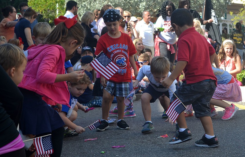 Children lined the sidewalks, grasping for candy thrown by parade marchers.