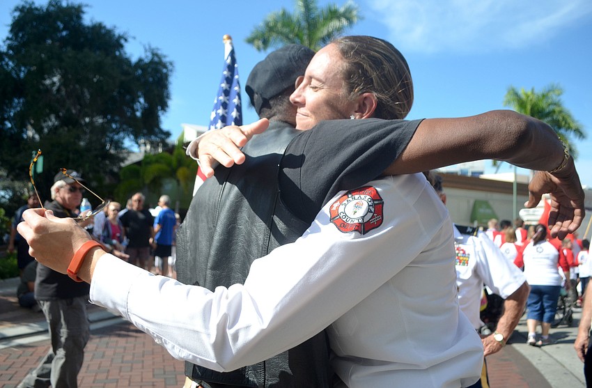 Anthony Jay hugs his friend, Sarasota County fire medic Patty Wacha after spotting her on the sidewalk during Sarasota's Veterans Day parade.