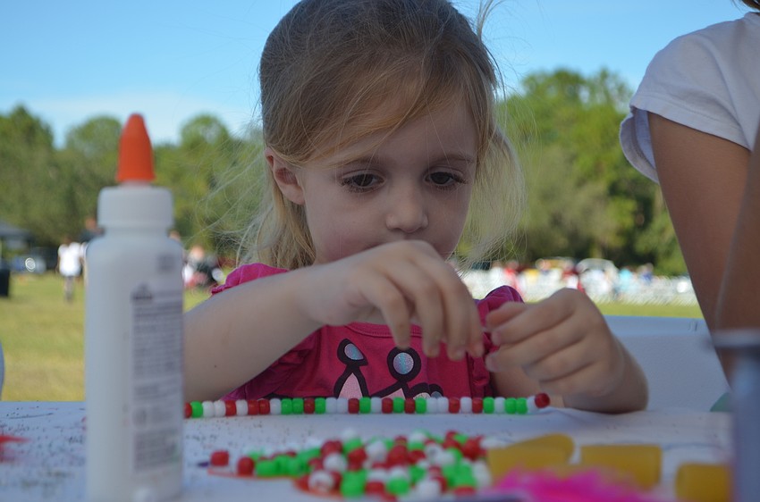 Lakewood Ranch's Allison Broderick, 4, makes an Italian-themed necklace.