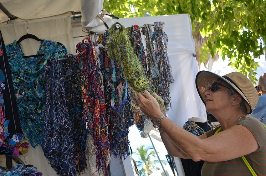 Elaine Kampmann looks at scarves from Handmade Chenille made by Ira and Sue Lances.