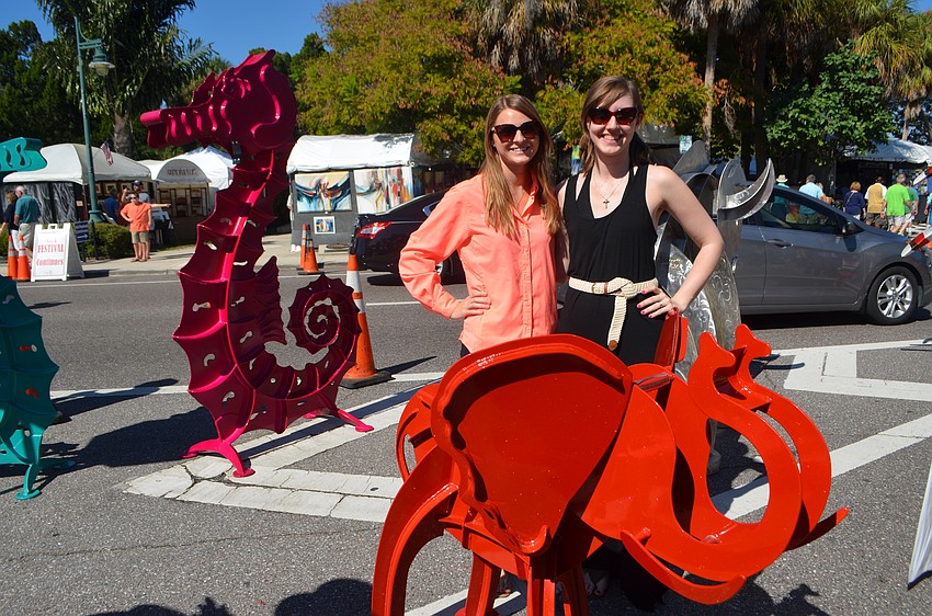 Joanna Cichowicz and Kathryn O’Reilly pose with a red elephant kinetic sculpture.