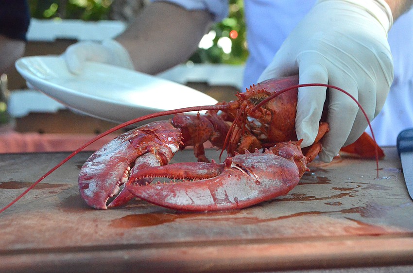 The Michael’s On East catering staff serves lobster to attendees.