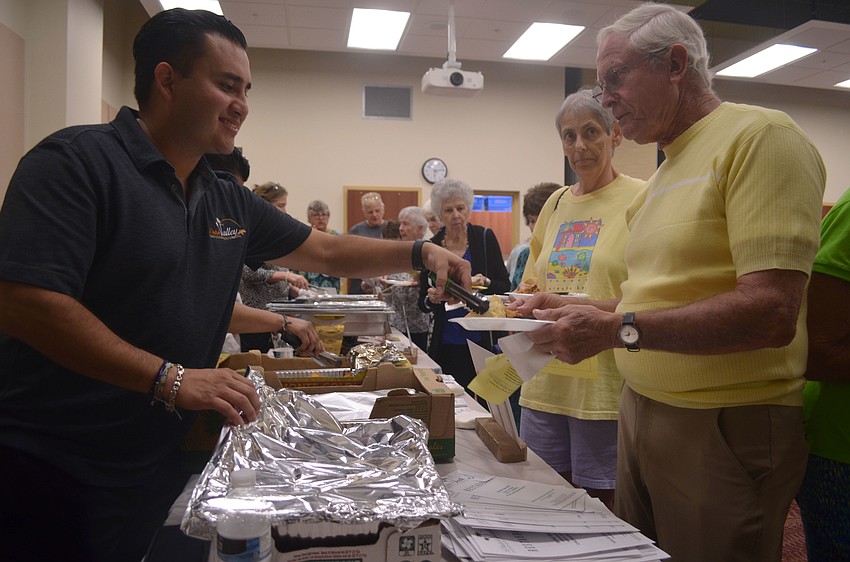 Arturo Perez serves Tom Hurban at the Taste of Gulf Gate event at the Gulf Gate Public Library.