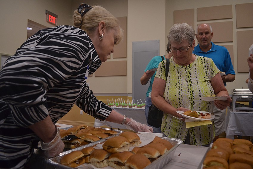 Chris Charlton serves Sheryl Lazzarotti a sandwich.