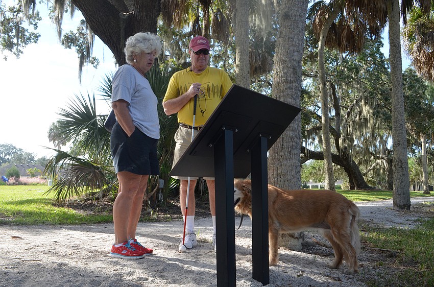 Betsy and Mike Calhoun read on of the informational signs posted along walkways at Phillippi Park. The signs were posted as part of the 100th anniversary celebration.