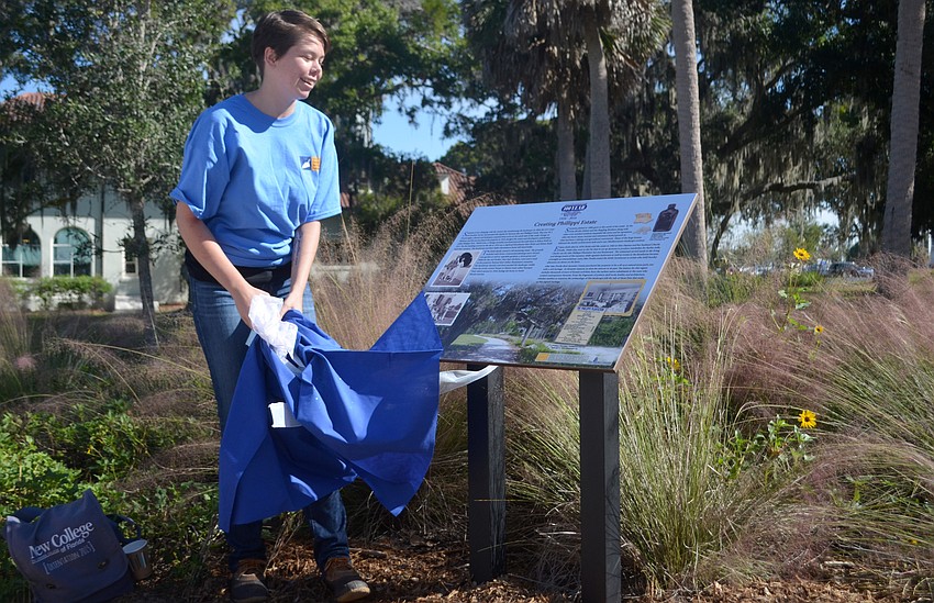 Oriana Reilly pulled a sheet of one of the informational signs posted around the property for the ceremonial unveiling of the placards.