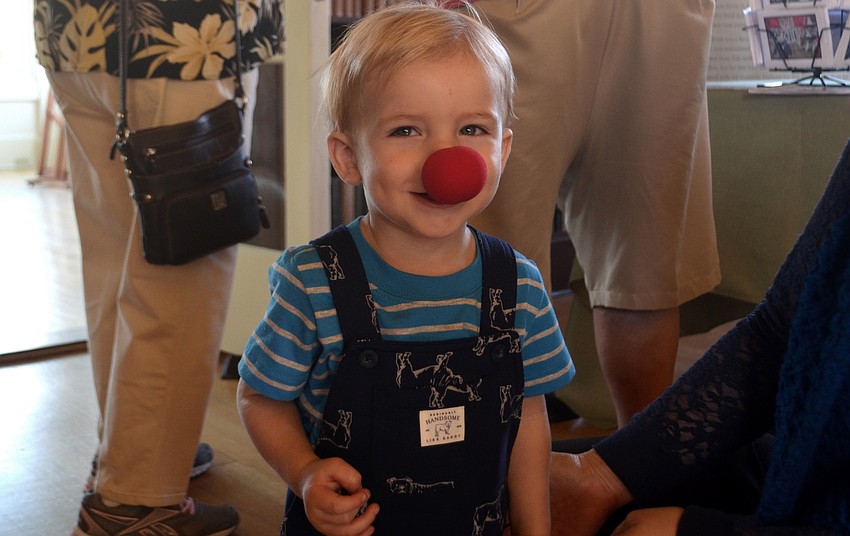 Finn McBaine, 1, poses with one of the clown noses left over from the exhibit's debut the night before.