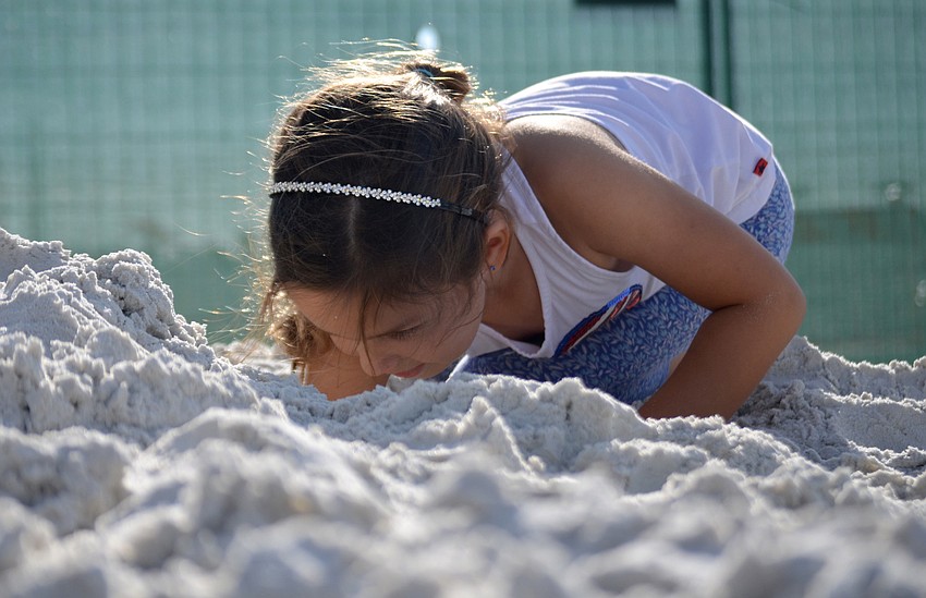 Jillian Haber digs in the pile of sand set aside for children's play.
