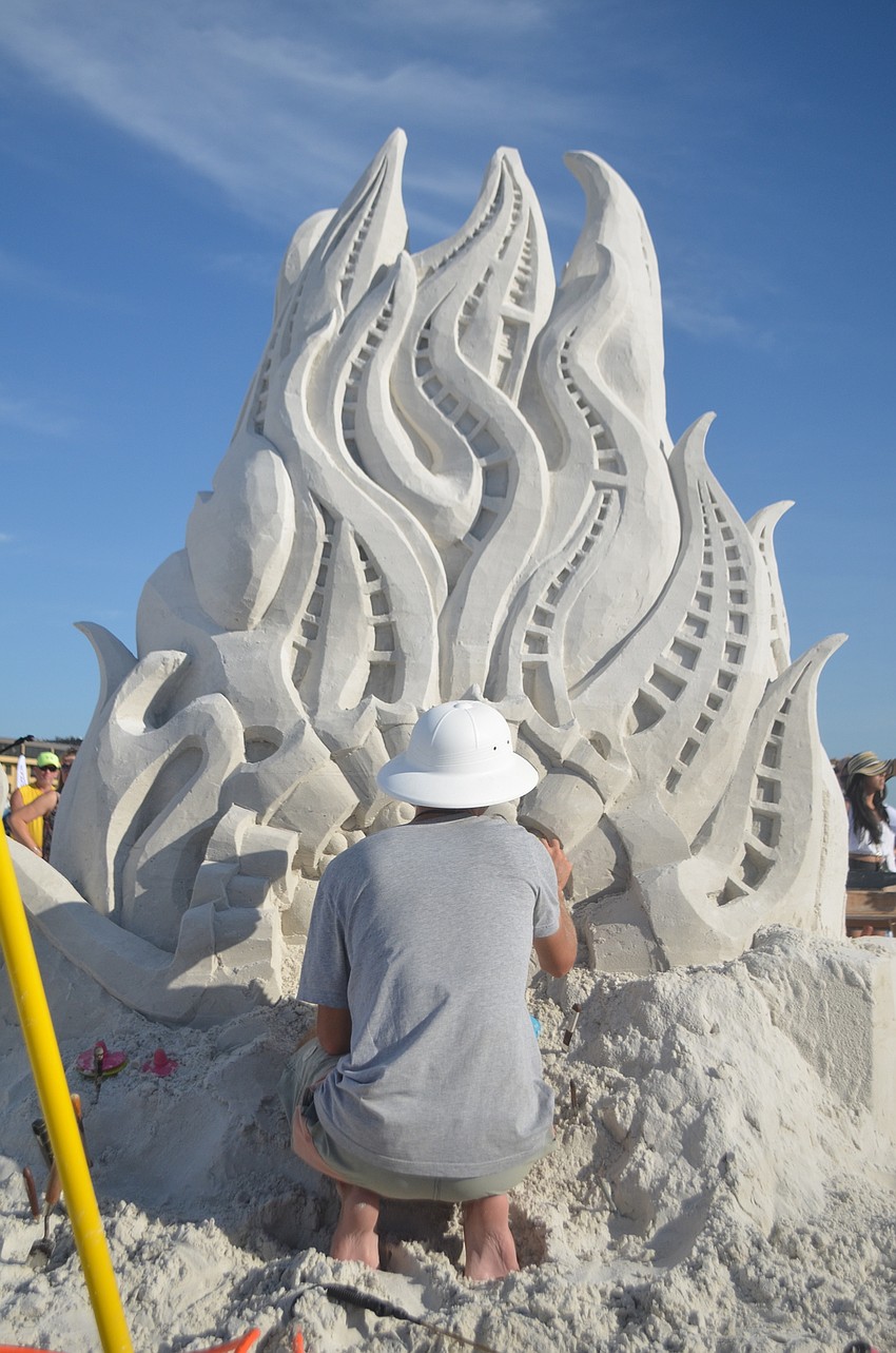 Emerson Schreiner sculpts his team's submission to the this year's Crystal Classic sand sculpting festival.