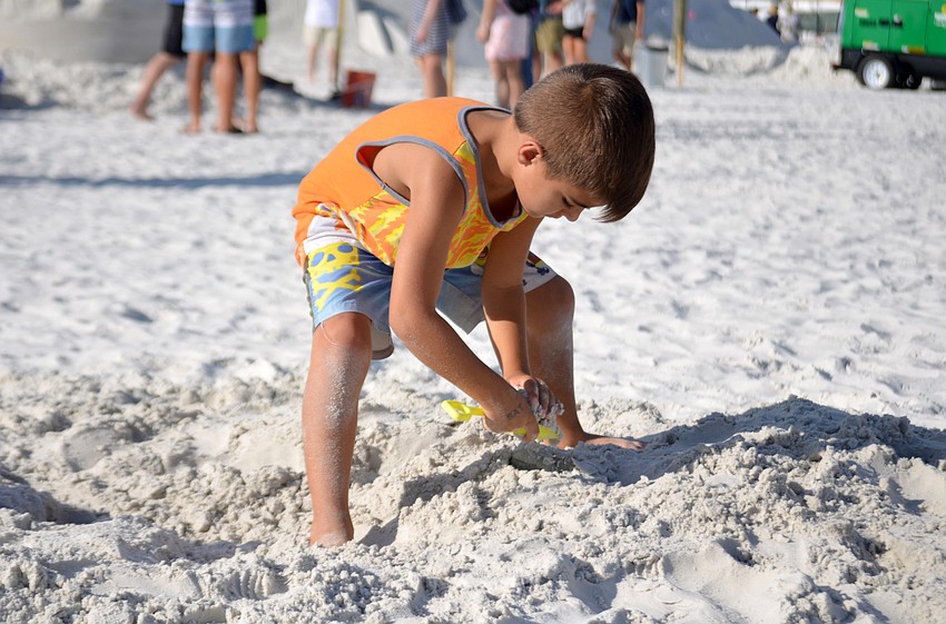 Gabriel Guerrero digs in the sand near the amateur sand sculpting area.