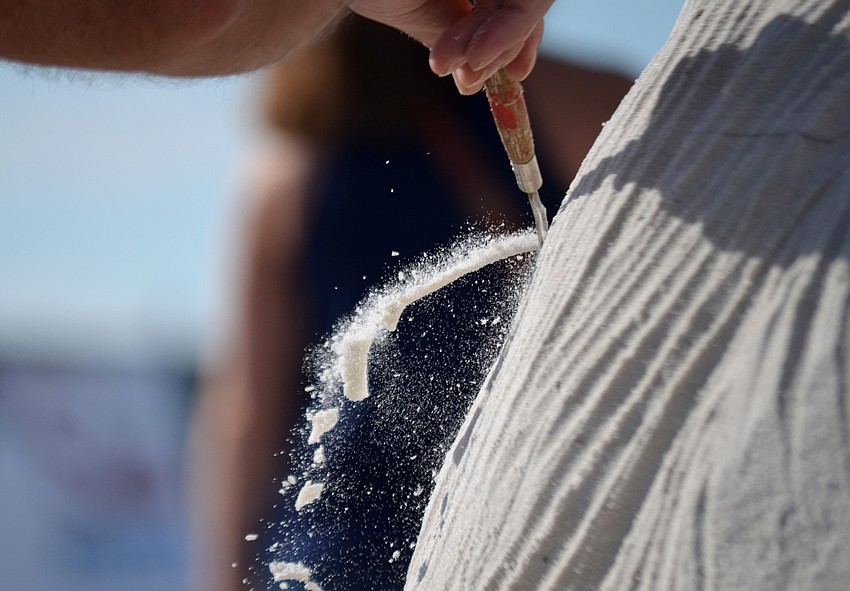 Sand falls as Fergus Mulvany sculpts during Siesta Key's Crystal Classic on Saturday.