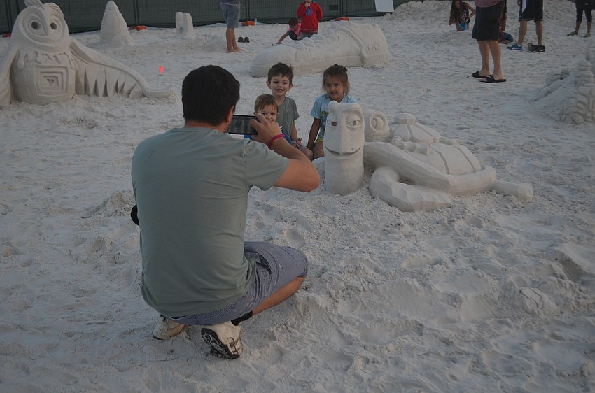 Alex Kharitonenko takes a photo of Andrew, Lucas and Elliana Kharitoneko next to one of the sculptures in the amateur sculpting area.