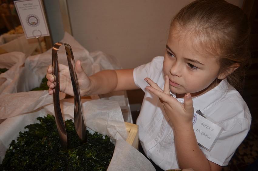 First grader Bella Smith samples the kale chips before families arrived at Southside's Farm to Fork dinner Tuesday night. 