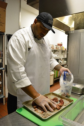 Capital Grille Executive Chef Kendell Emmanuel bags up cooked meat to be donated to the Salvation Army.