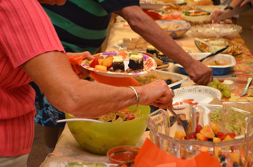 Guests pile fruit salad on their plates during Seaplace’s Welcome Back Dinner on Nov. 16.