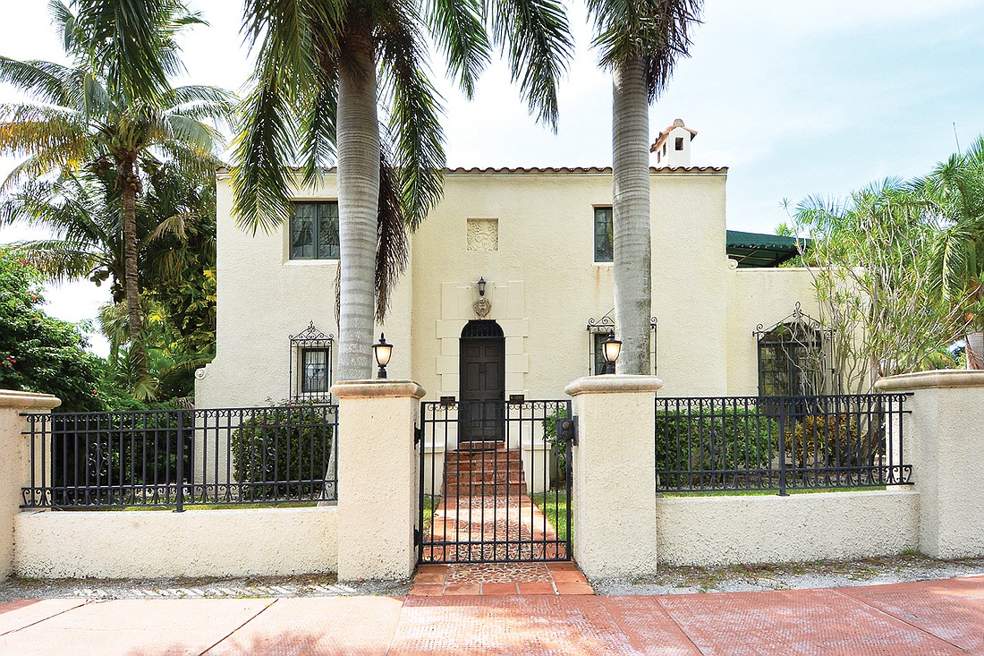 Two of the propertyâ€™s 19 royal palms frame the front entrance. Over the doorway is a profile bust of a Roman soldier. Wrought iron grills grace the first-floor windows.