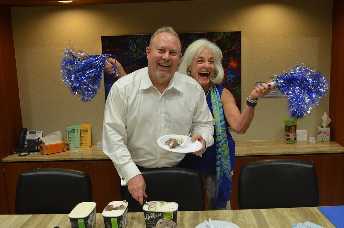 Douglas S. Staley, CEO of Child Protection Center, laughs as Graci McGillicuddy cheers him on during their ice cream party.