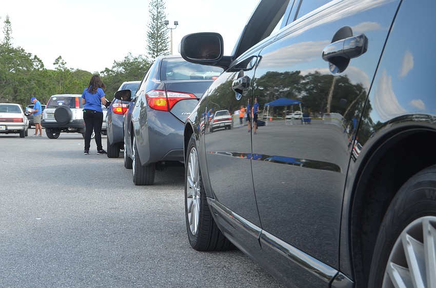 Cars line up in the Robarts Arena parking lot to receive a turkey during the All Faiths Food Bank's annual turkey giveaway.