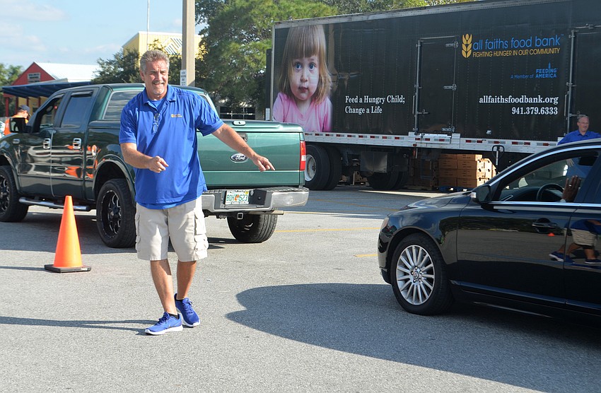 All Faiths Food Bank Chief Operations Officer John Livingston directs traffic during the turkey drive.