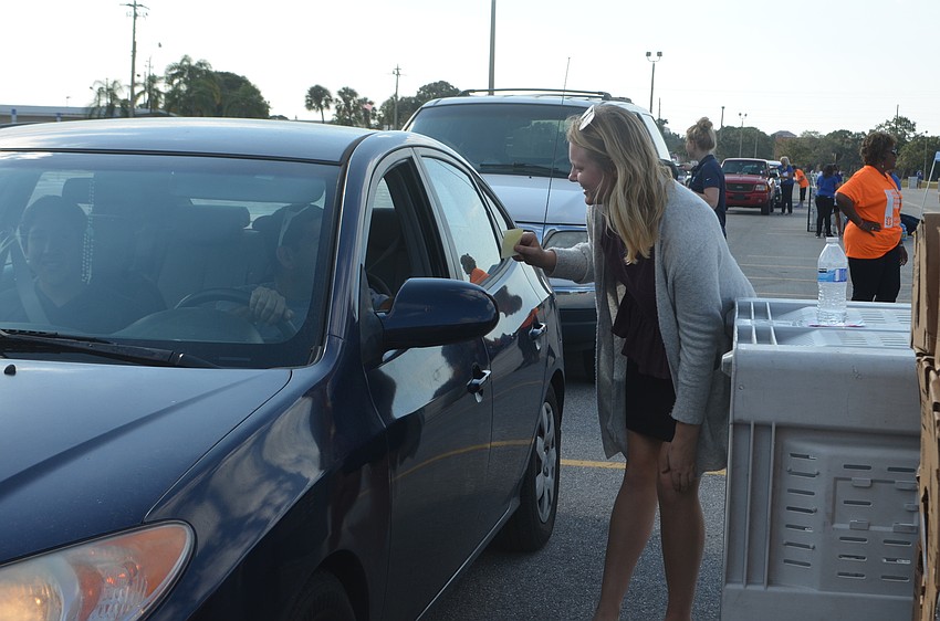 Anna Wellman helps direct a recipient during All Faiths Food Banks turkey giveaway.