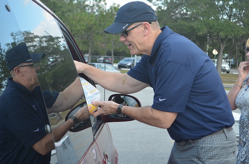Jay Clarkson passes a turkey into the front window of one of the turkey  recipients.