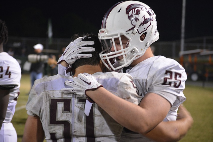 Braden River senior linebacker Noah Arce is comforted by junior linebacker Chase Knopf.
