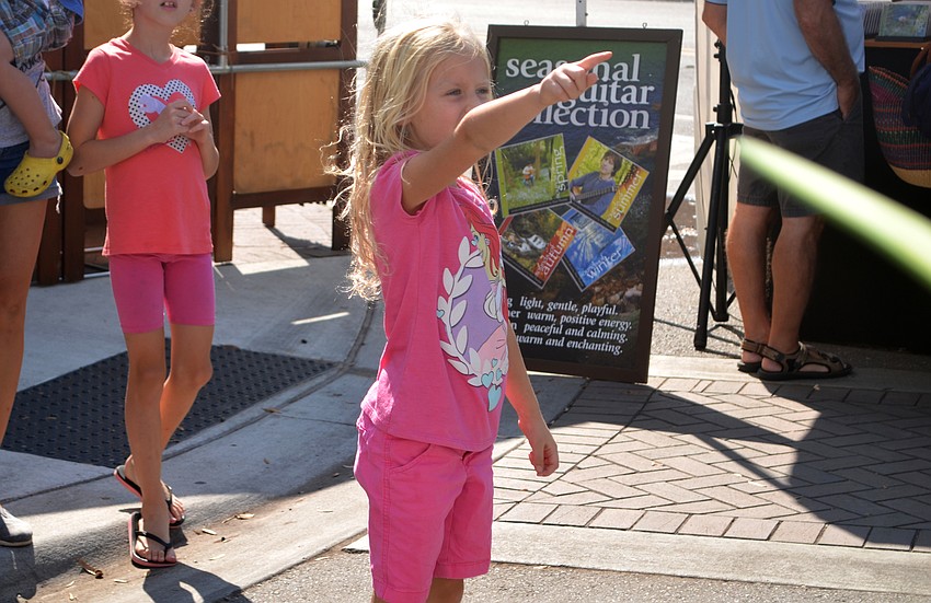 Allison Hill points at a sculpture featured at Sarasota Fall Fine Art Festival.