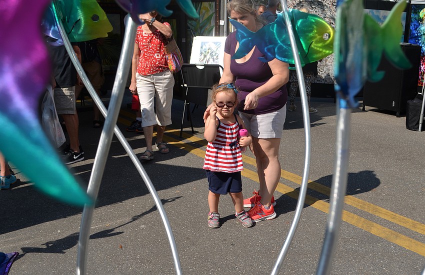 Macaylah Lanie looks at a revolving fish sculpture.