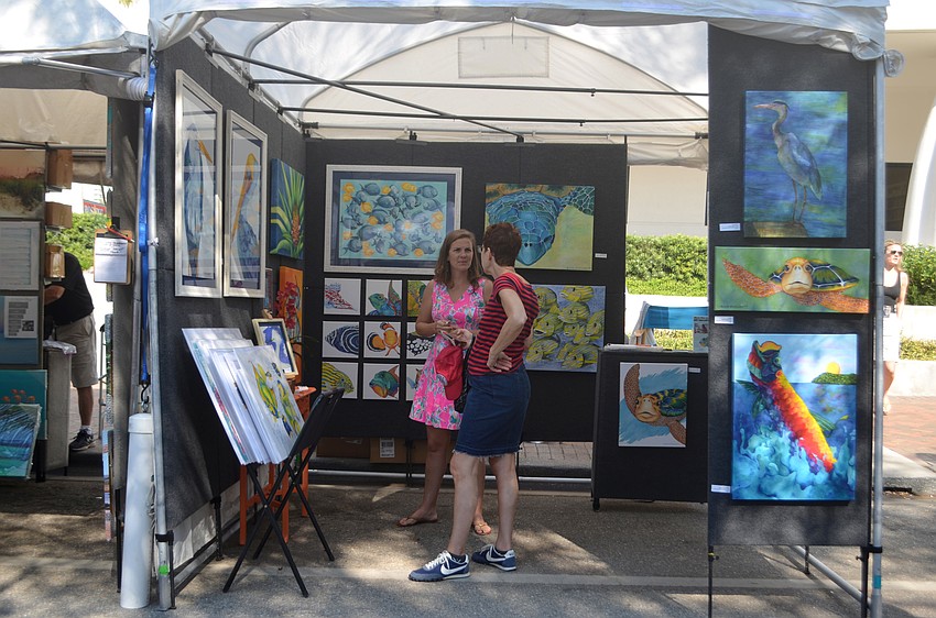 Bonnie Korsgaard chats with Michelle Nicole Lowe inside Lowe's tent at the Sarasota Fall Fine Art Festival.