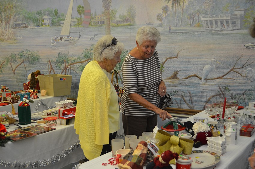 Patricia Cotty and Jane Thompson peruse the tables at the St. Mary Christmas Bazaar on Nov. 19.