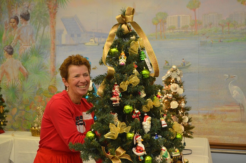 Mary Lou Ivaska laughs as she moves a Christmas tree during the St. Mary Christmas Bazaar.
