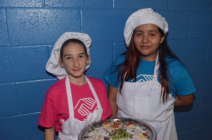 Whitney, 14, and Jasmine, 13, serve hors d'     oeuvres to guests.