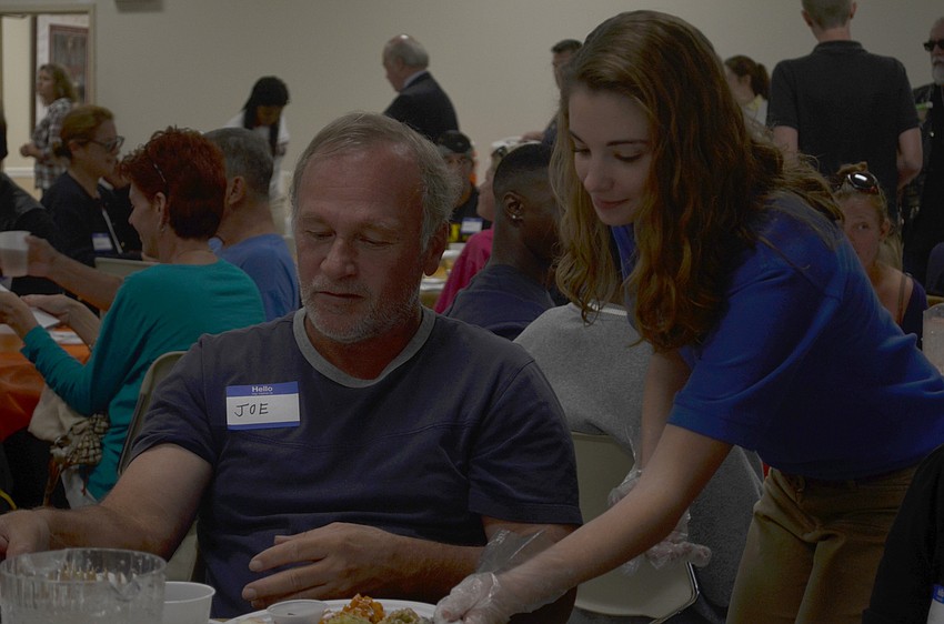 Lauren France serves Joe Faust at Sarasota Ministerial Association’s 16th annual Thanksgiving Luncheon.