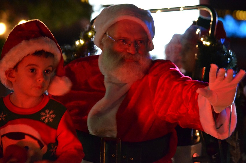 Santa waves to children lining Ocean Boulevard during the Light Up The Village parade Saturday, Nov. 26.