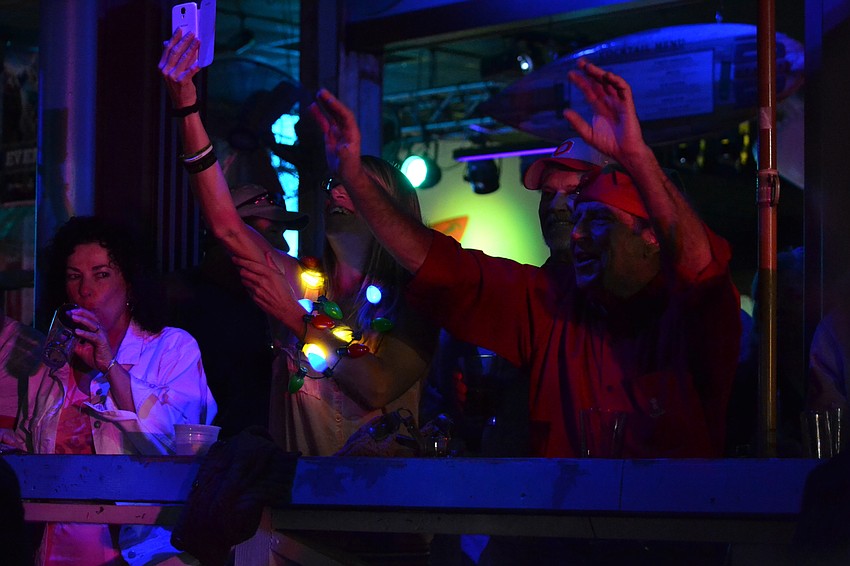 Sheila Troyer and Richard Dudek wave from the Beach Club deck to Santa.