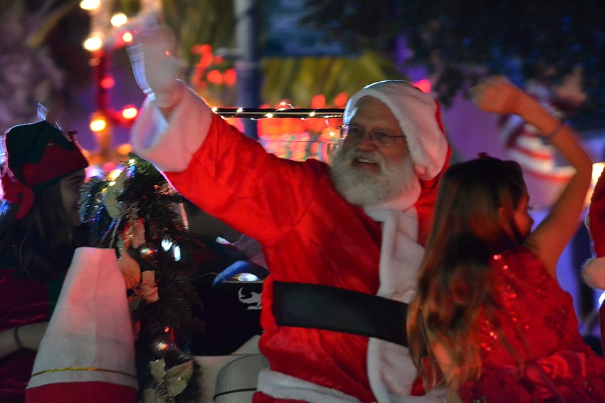 Santa waves to children lining Ocean Boulevard during the Light Up The Village parade Saturday, Nov. 26.